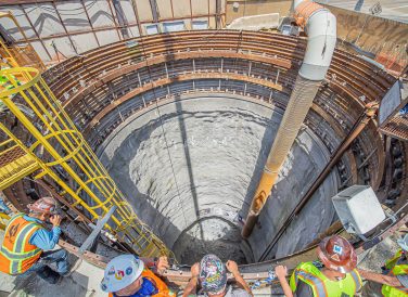 construction workers at hole entrance at Mill Creek Tunnel dig site